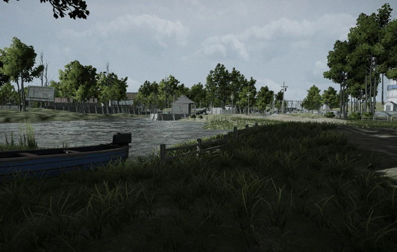 A blue rowing boat with an outboard motor sitting in long grass on a riverbank, a fence running down to the flooded water, sheds and a pylon on the far shore